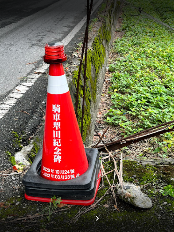 花蓮吉安鄉慶豐四街和北安街路口的紅色三角錐，上面寫著七個大字「騎車犁田紀念碑」。 圖：翻攝自Google地圖