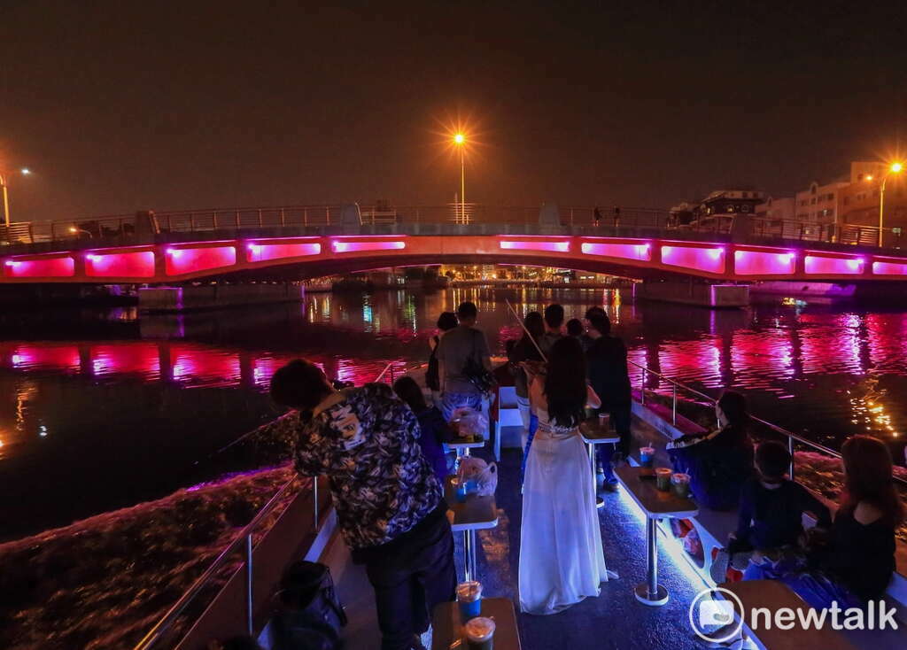 遊客搭船夜航可倘佯於運河水域素雅金色光環境之間，搭配運河兩岸街道大樓燈光水影，感受運河早期居民水路往返安平至市區的航行歷程。 圖：台南市政府提供