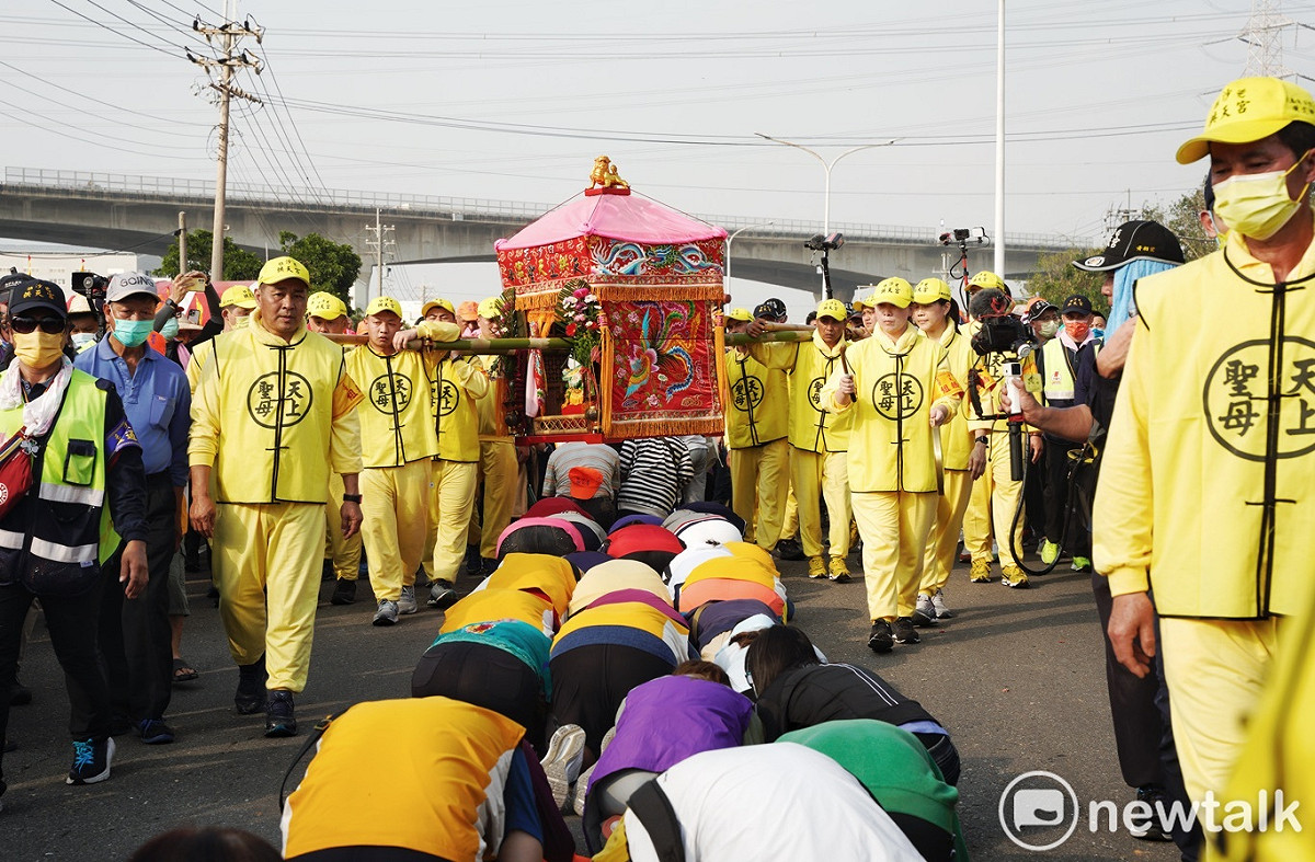 白沙屯媽祖經過台中市龍井區時，當地信眾頂禮膜拜鑽轎腳。 圖：張良一/攝
