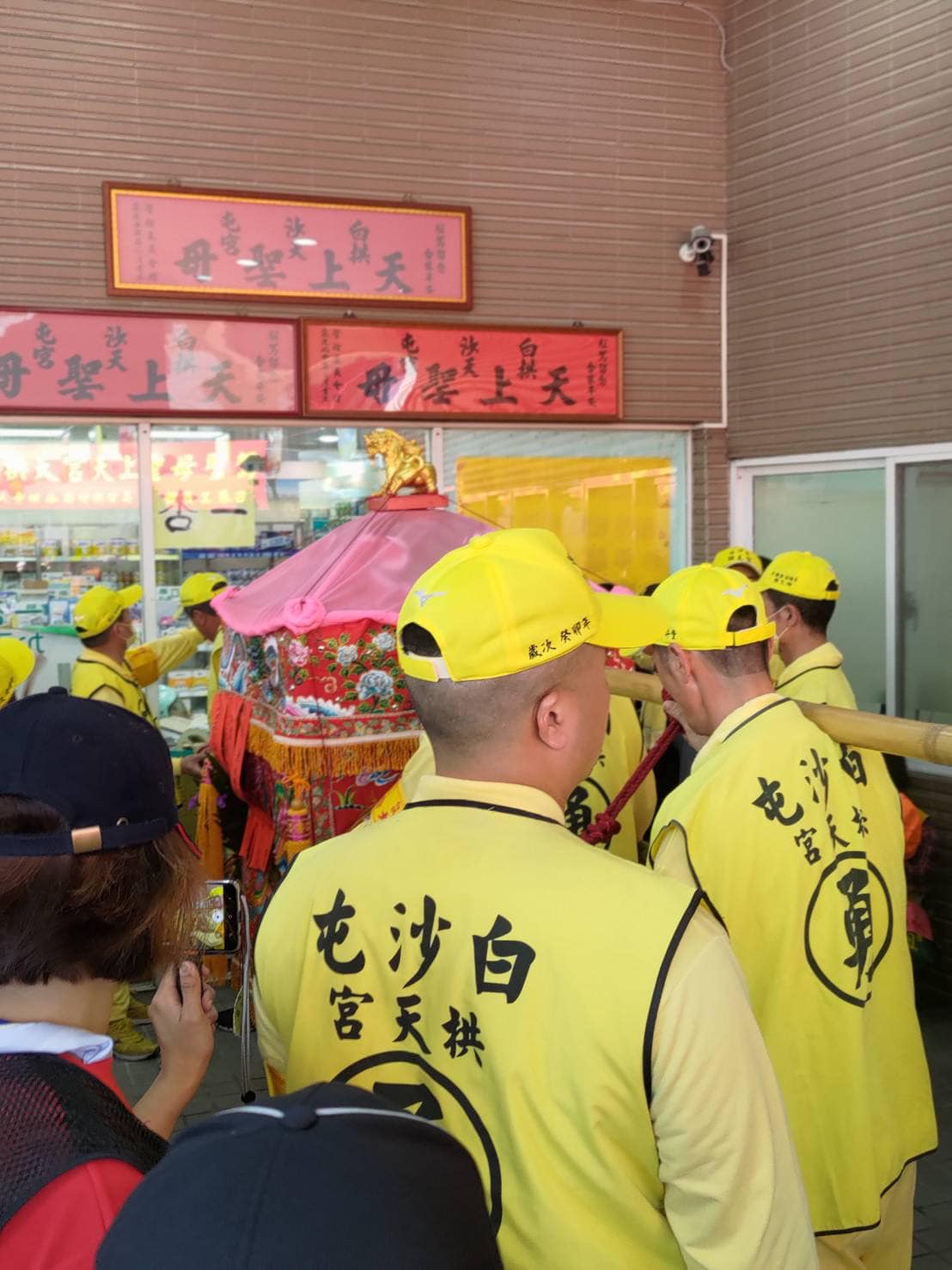 白沙屯媽祖進香隊伍今天轉進童綜合醫院沙鹿院區時，媽祖鑾轎不斷在院區一處玻璃門前，前後搖動不離開，原來是要指示白沙屯媽祖匾額的地點不適當。 圖：白沙屯拱天宮