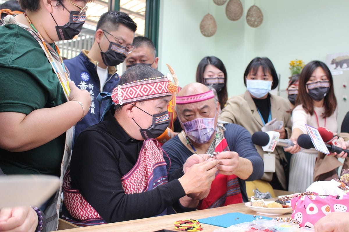 侯友宜與日照中心長者學習，將薏苡串成手鏈，戴在手上代表祝福與平安。 圖：新北市衛生局提供