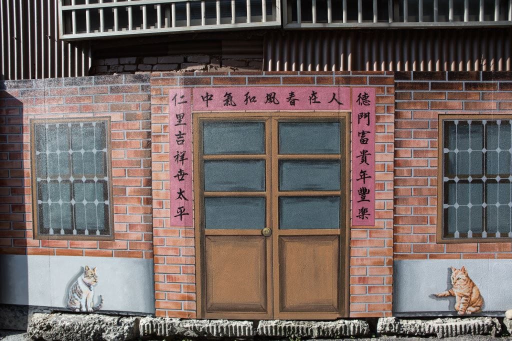 美仁里彩繪巷內的壁畫，記錄了居民往昔的生活。壁畫上的母貓，在對公貓說些什麼呢？ 圖：翻攝自台中觀光旅遊網