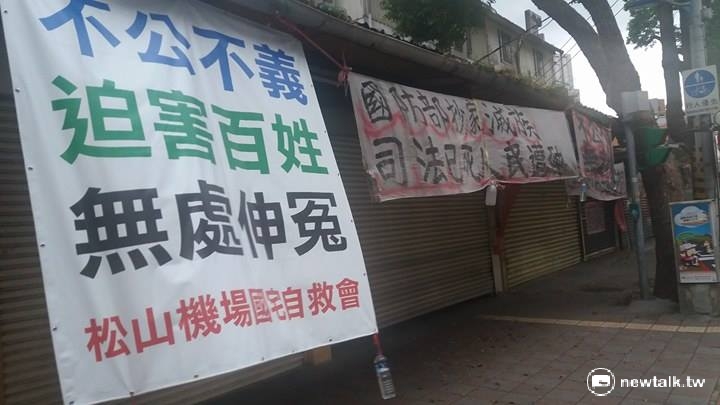 台北市松山機場旁，大馬路上的每一戶都高起掛布條，用「國防部抄家滅族，司法已死人民遭殃」，控訴不公。 圖：程士華/攝