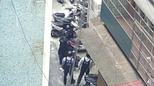 新北市新店警方30日疑似要逮捕自稱是天道盟太陽會總顧問的劉邦誠，在中和街頭發生駁火，互開30多槍，劉 疑似躲進公寓頂樓與警方對峙。圖為警方進入右邊轉角 建物攻堅，對峙喊話。 圖:中央社