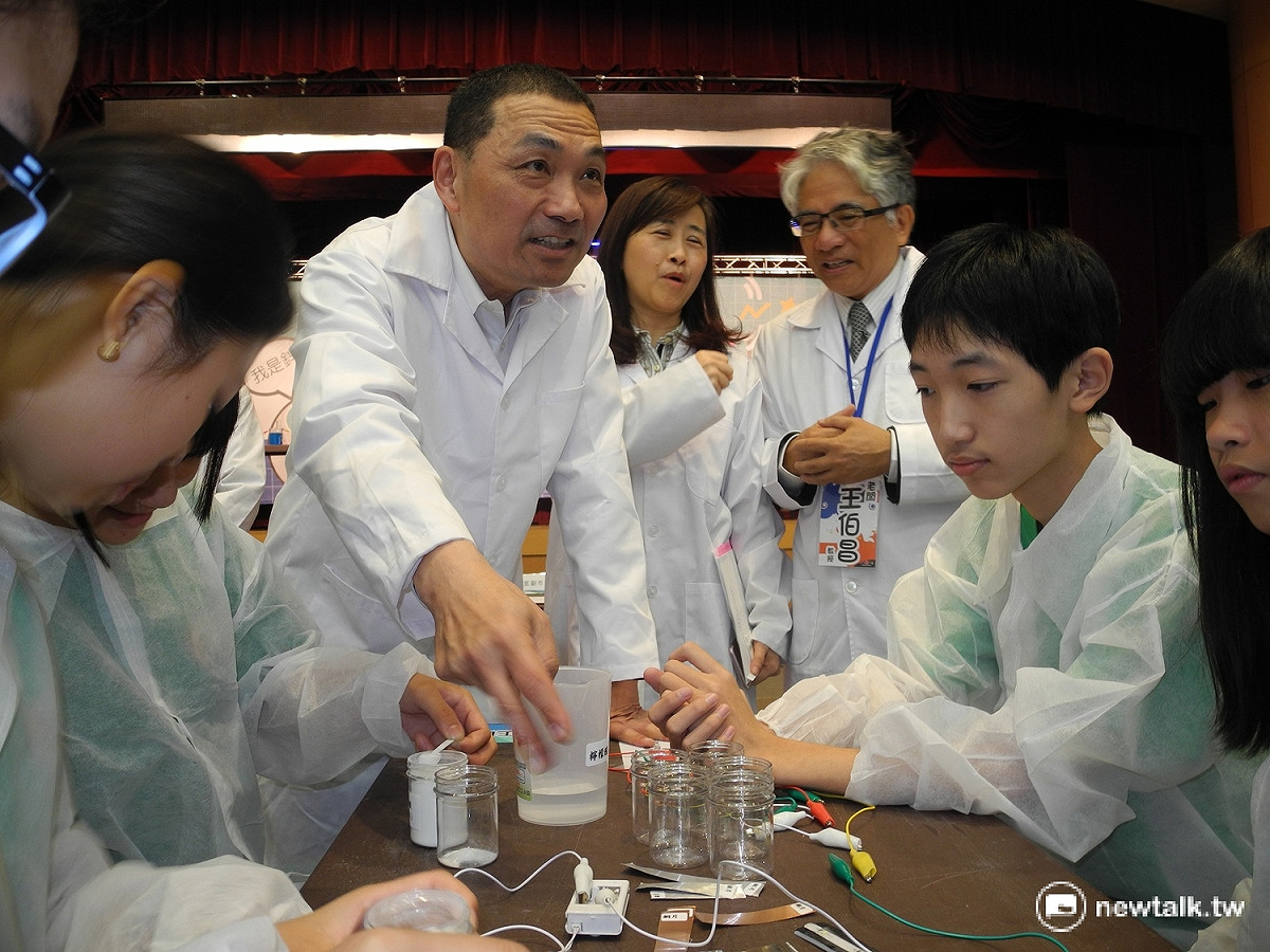 侯友宜觀看國中組學生進化「鋅銅化學電池」實驗，不時出手指指點點，好奇心十足。 圖：王峻昌／攝