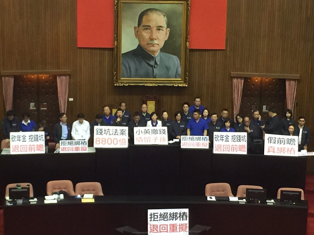 國民黨立法院黨團因為反對前瞻基礎建設計畫，2日上午再度占領院會主席台；國民黨立委在主席台上高喊「拒絕綁樁、退回重審」，並高舉「砍年金挖錢坑、退回前瞻」、「假前瞻、真綁樁」等字牌 。 圖：林人芳／攝