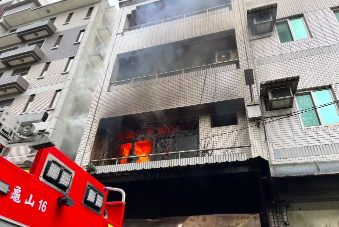 ▲桃園市龜山區自強南路一處民宅，今（26）日上午10時許突發大火，消防局獲報趕赴現場救援，現場1樓全面燃燒，其中受困3樓的15歲未成年少年被救出時，已經沒有生命跡象，而受困4樓的2人由雲梯車救出，3人皆送往醫院搶救。 圖／nownews提供