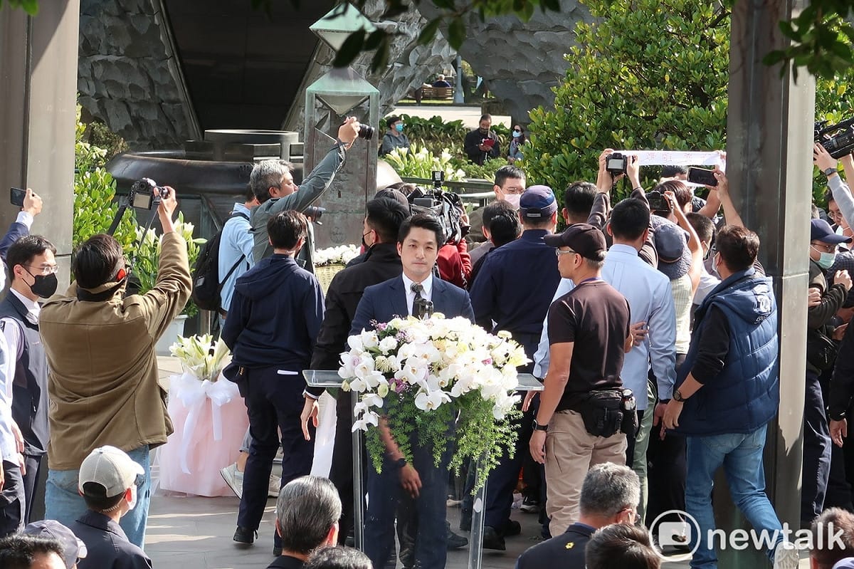 台北市長蔣萬安致詞時遭逢抗議，抗議者手舉「殺人兇手、下跪道歉」布條。 圖：林朝億/攝