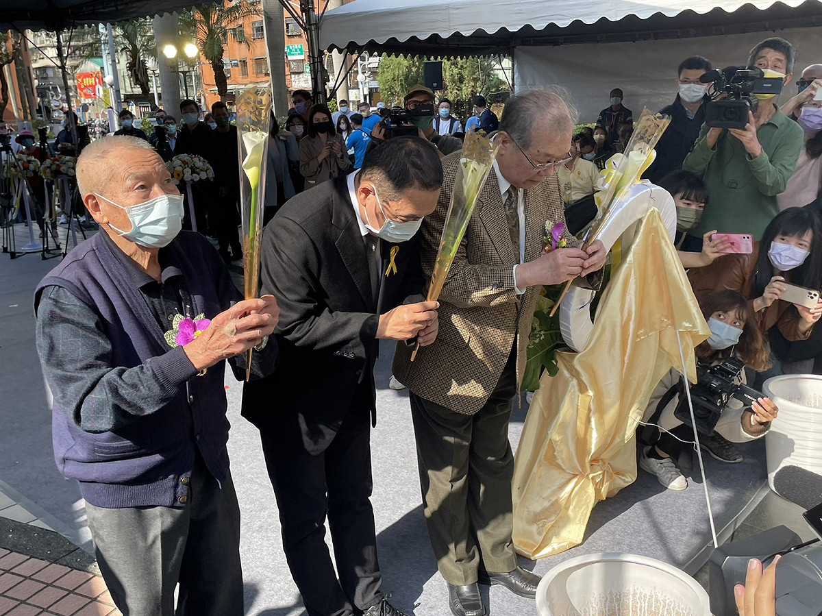 新北市長侯友宜(中)與理事長洪顯詔(右)、二二八受難者趙水濱(左)手執鮮花於紀念碑前獻花。 圖:新北市民政局提供