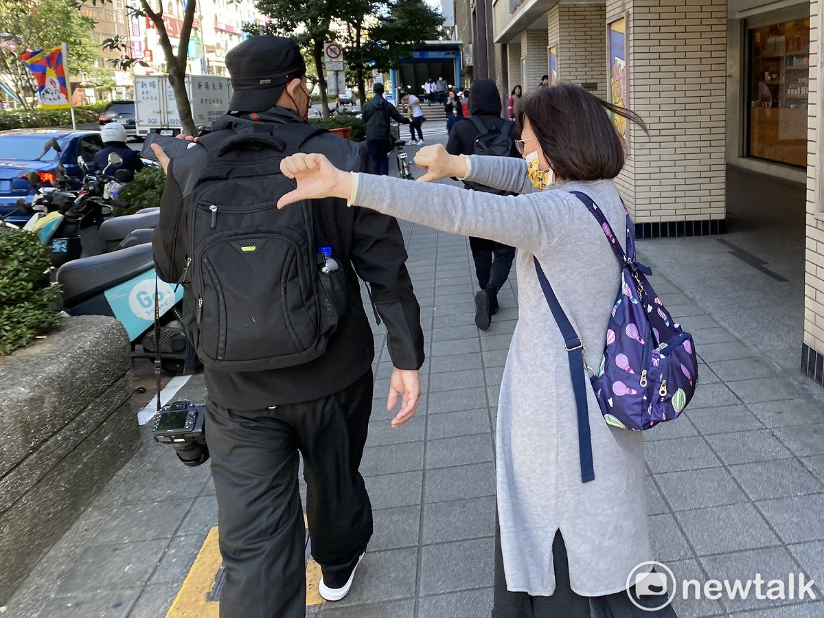 310西藏抗暴日64週年大遊行今天登場，一名婦人站在人行道上頻對遊行隊伍比倒讚。 圖：周煊惠 / 攝