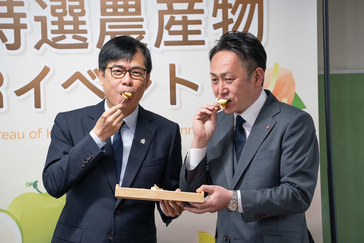 陳其邁(左)r與進口商社長田中伸幸試吃「蜜棗加烏魚子」。 圖：高雄市農業局/提供