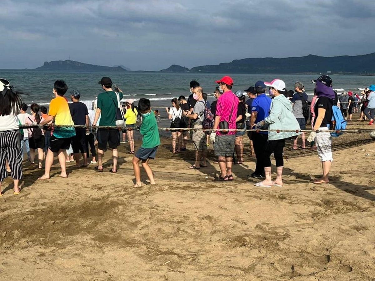 民眾體驗「牽罟」活動，齊心協力將罟網往岸上拉。 圖：新北市觀旅局提供