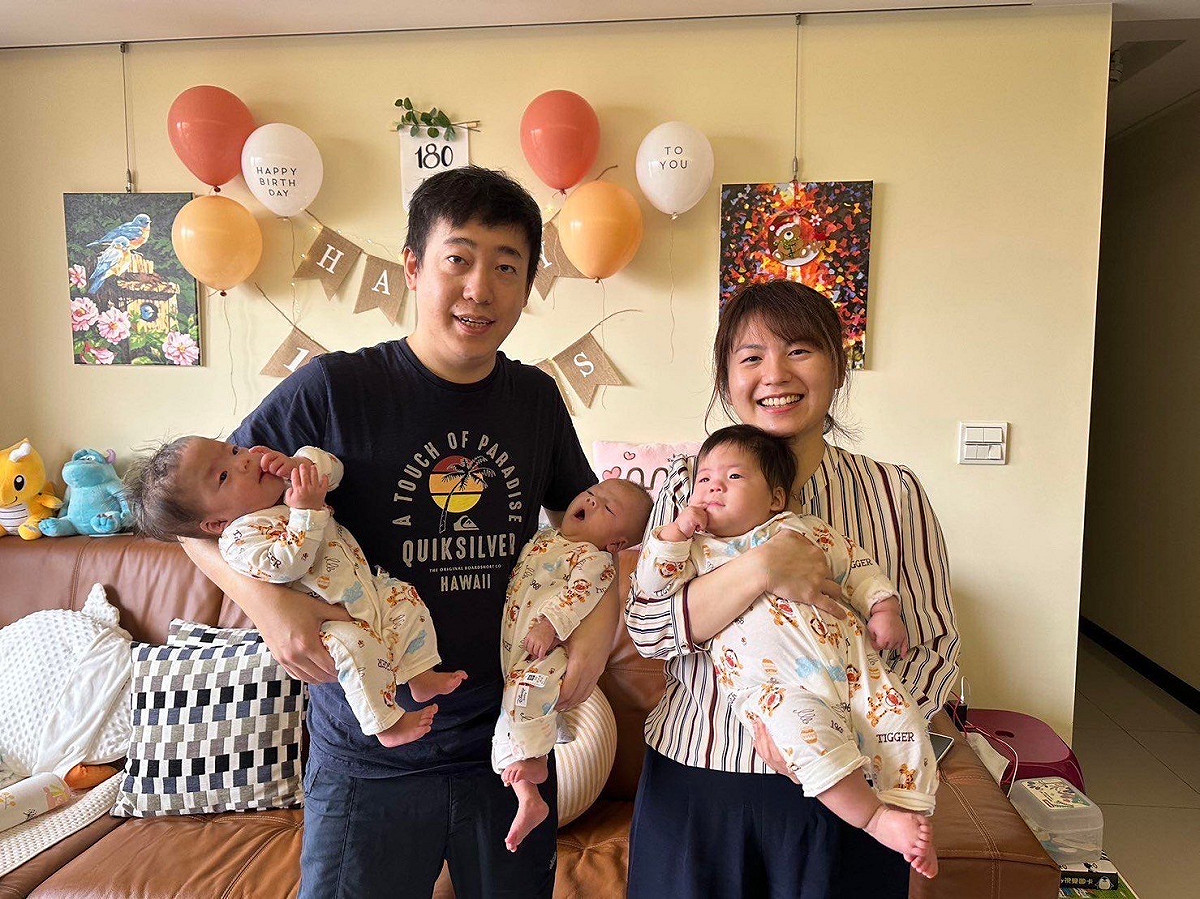 郭小姐夫妻手抱三寶(左到右為二寶、三寶、大寶)臉上洋溢幸福喜悅。 圖：蕭勝文／提供