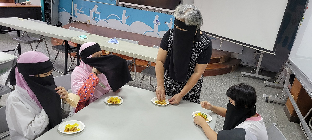 秀朗國小學生體驗穆斯林用右手抓飯吃的基本禮儀。 圖：新北市教育局提供