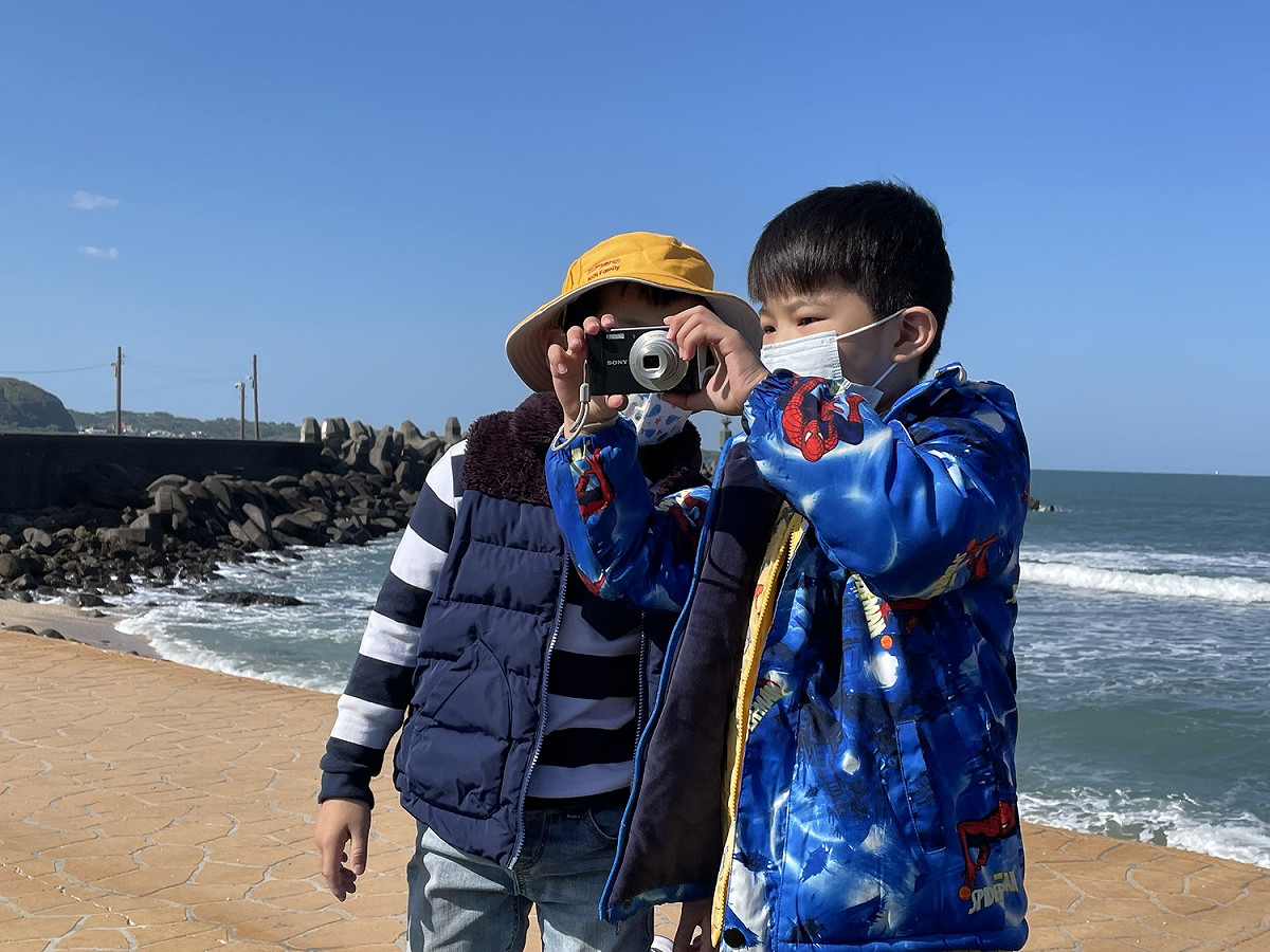 踏查時，幼兒拿著相機記錄石門之美。 圖：新北市教育局提供