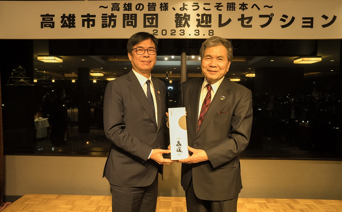 陳其邁(左)送熊本縣知事蒲島郁夫荔釀酒。 圖：高雄市政府/提供