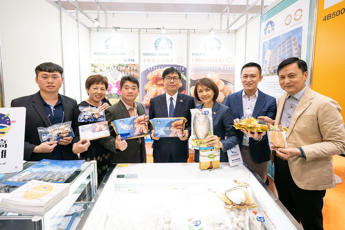 陳其邁(中)於東京食品展為高雄海味廠商加油打氣。 圖：高雄市行政暨國際處/提供