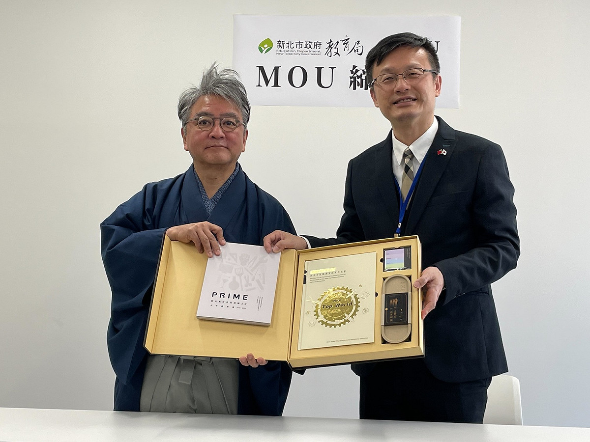教育局長張明文（右） 特地致贈剛發表的技職教育政策白皮書，展現新北市推動技職教育的行動力。並IU大學校長中村伊知哉（左）相互期勉，合作的點滴將寫入未來4年的技職成果中。 圖：新北市教育局提供