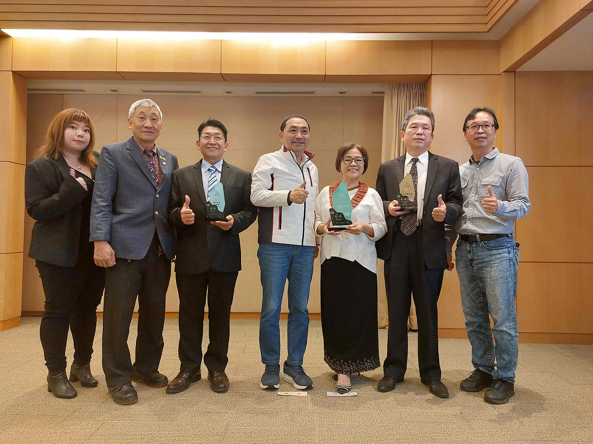 新北市烏來區觀光發展協會理事長高淑敏（右三）、新北市溫泉觀光協會理事長李玉郎(左三)以及業者代表，於今日市政會議上獻獎，分享新北市溫泉區獲得眾多台灣好湯獎項之殊榮。 圖：新北市觀旅局提供