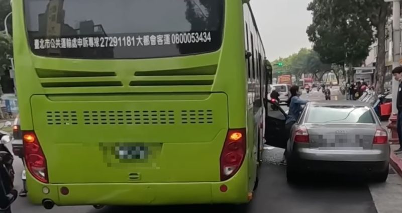 開著銀灰色奧迪轎車的女駕駛，將車輛違停在紅線上，下車時疑似未注意後方來車，就直接打開車門，下秒就被經過的公車撞歪車門。 圖／翻攝Wowtchout - 地圖型行車紀錄器分享平台