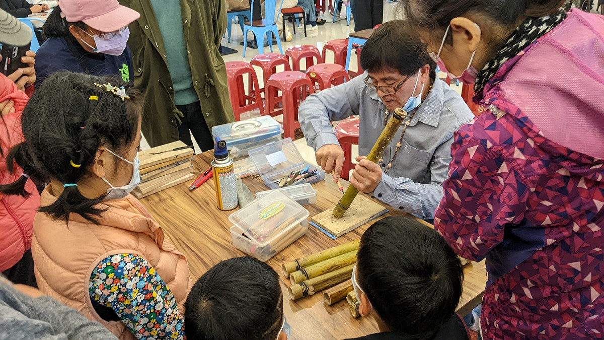 原住民族傳統技藝相當精采，圖為汐止成果展中老師謝金水現場教導民眾製作太魯閣族傳統獵笛。 圖：新北市原民局提供