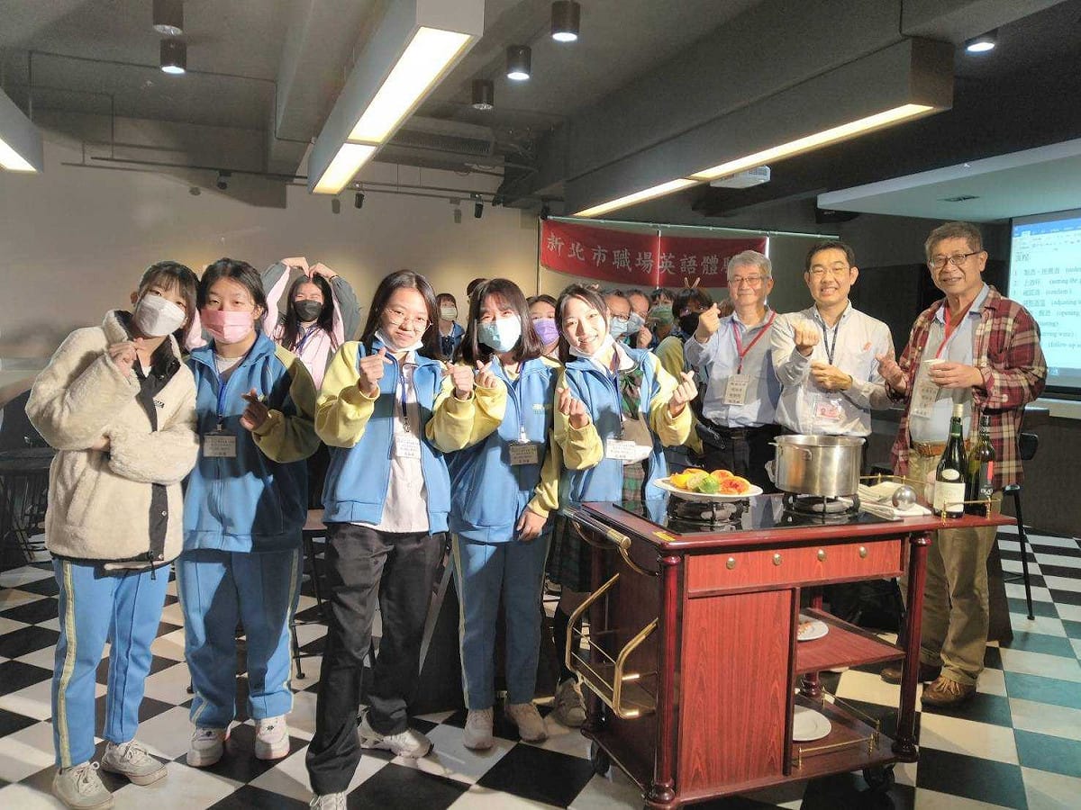 黎明技術學院觀光餐旅學群經由課程設計，讓學生真實體驗職場英語情境，新北市教育局技職科輔導員劉銘恩（右2）參與職場英語課程活動。 圖：黎明技術學院提供