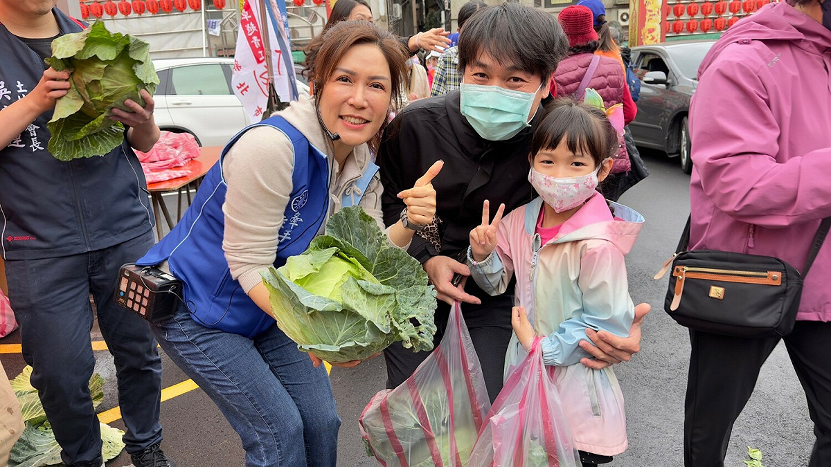 新北市議員林金結之妻潘素文與民眾一起手棒高麗菜合照。 圖：林金結服務處提供
