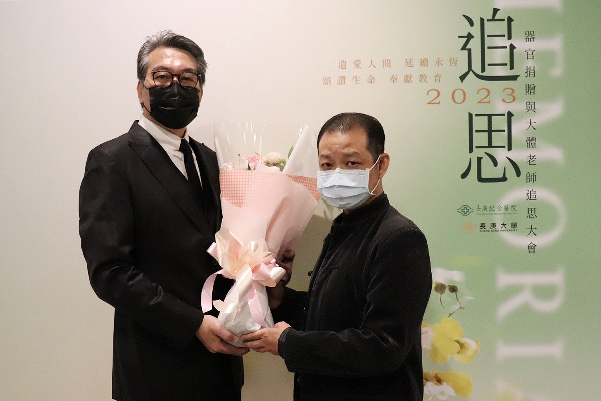 倪嘉元(左)代表受贈者獻花給捐贈者周奕翔的父親周竣源(右)。 圖：林口長庚醫院／提供