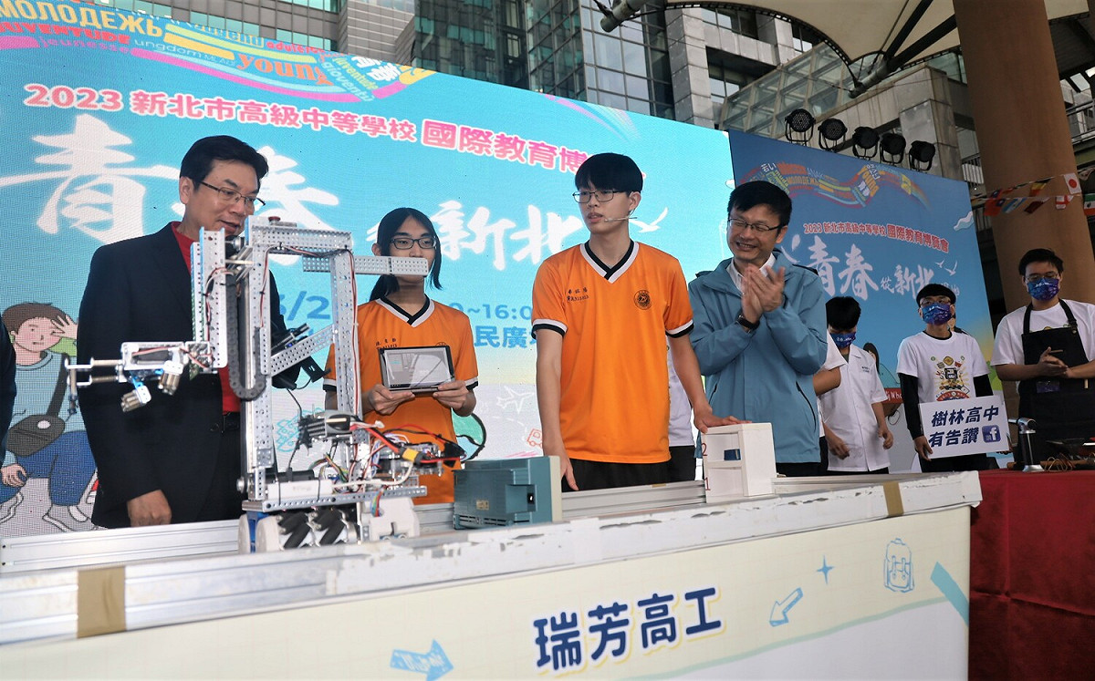 劉和然（左1）與瑞芳高工學生互動，學生以自動搬運系統模擬，展現技高專業技能。 圖：新北市教育局提供