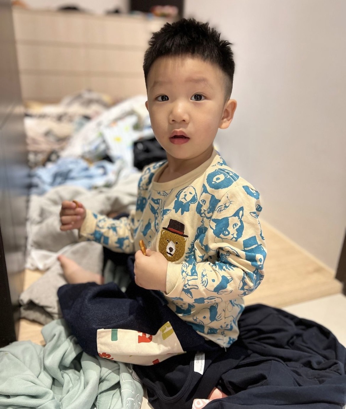 蔡波能在衣服堆上吃餅乾。 圖：翻攝自蔡波能IG
