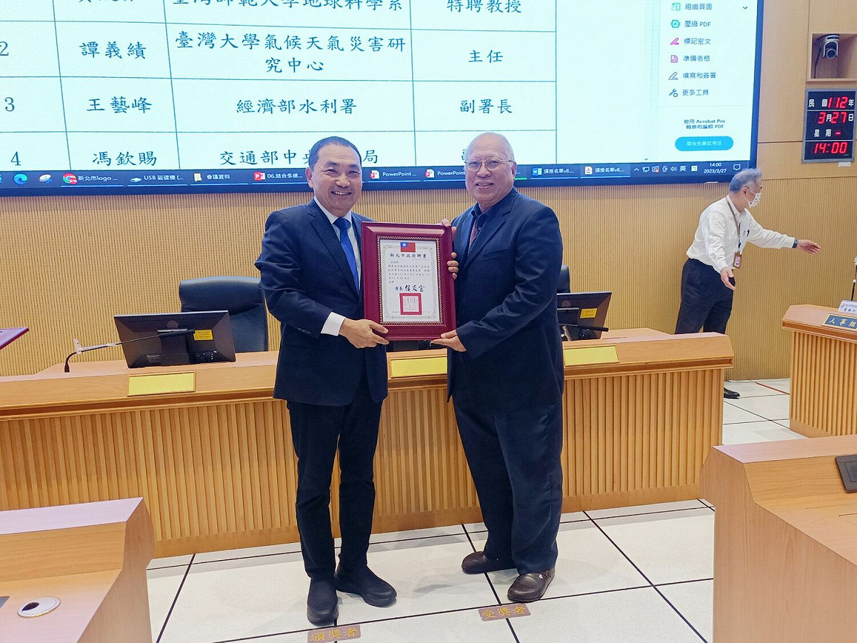 新北市長侯友宜特別親自頒授聘書給台灣大學氣侯天氣災害研究中心主任譚義績。 圖：新北市消防局提供