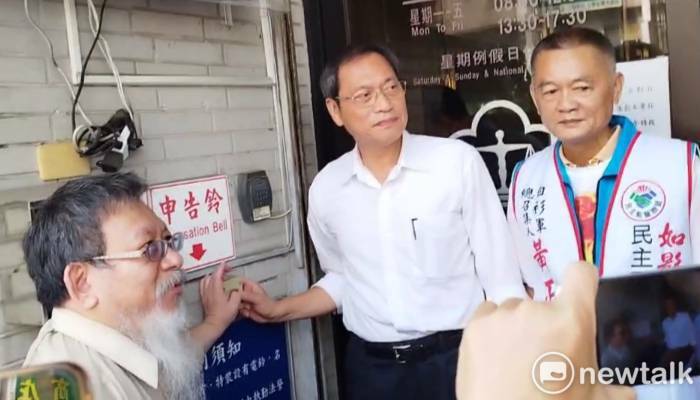 蘇清泉(中)在張靜陪同下按鈴提告選務人員。 圖：孫家銘攝