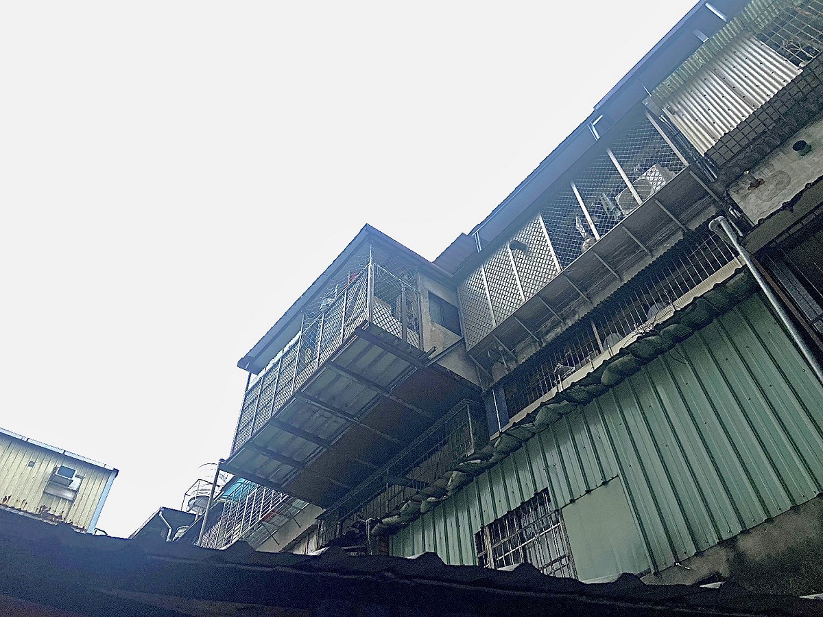 新莊區西盛街一處老舊公寓，外推違建懸掛空中有安全之虞。 圖：新北市工務局提供