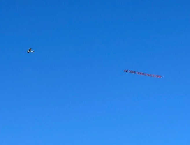 中國僑民租小型飛機橫掛「One China!Taiwan is part of China!」布條 圖：翻攝自推特