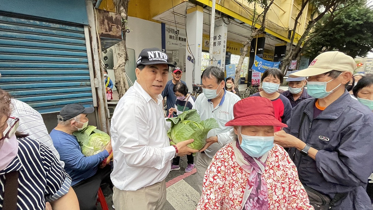 新北市議員周勝考(戴帽者)有鑑於近日高麗菜產地價格下跌，發起帶發票換高麗菜。 圖：周勝考服務處提供
