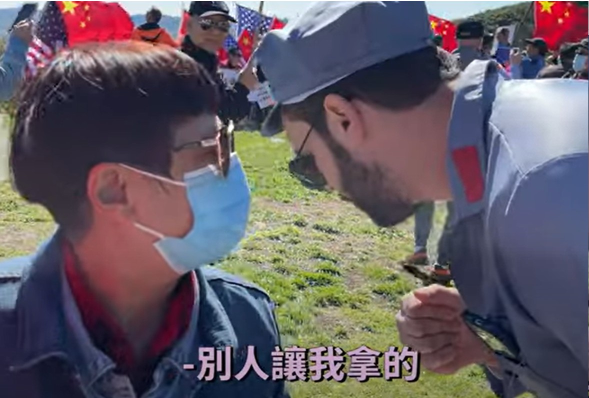 一名拿著收音機播放抗議話語的中國走路工告訴樂樂法利「別人要我拿的」。 圖：翻攝樂樂法利YouTube影片