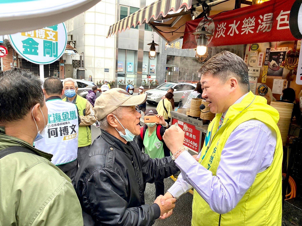 民進黨新北市第1選區立委候選人何博文前進淡水清水街市場拜票，遇到多位鐵粉。 圖：何博文服務處提供
