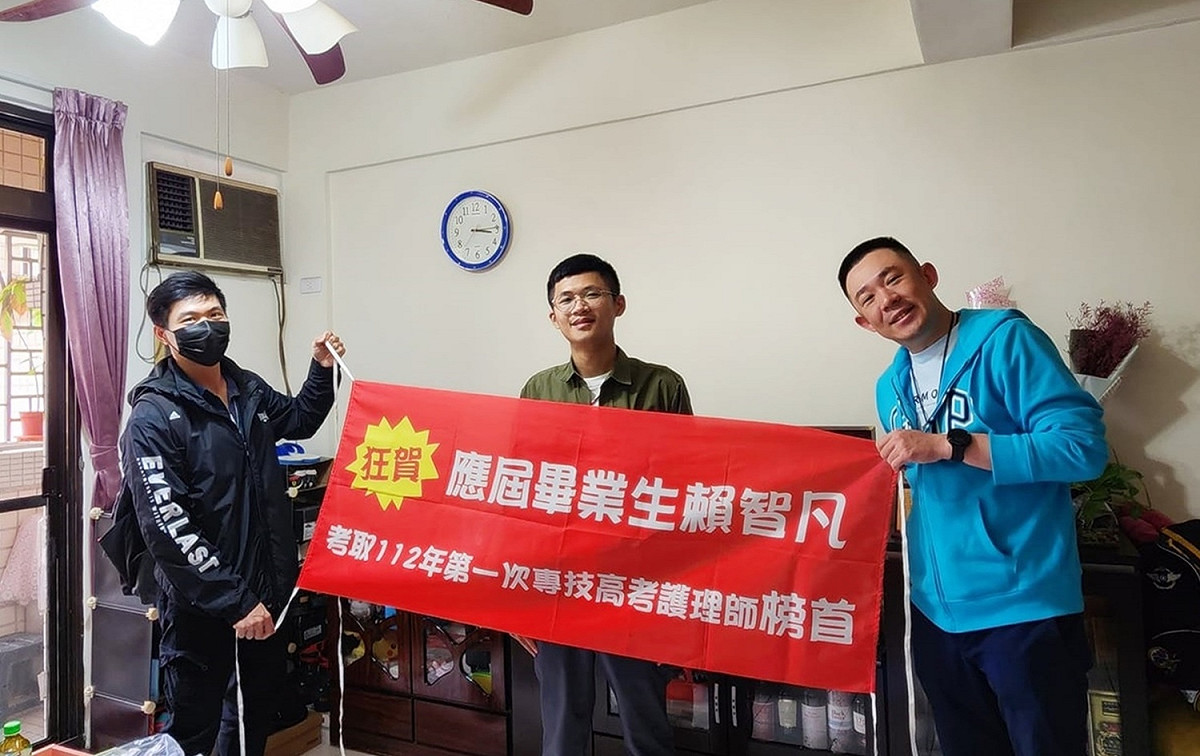 學長製作紅布條慶賀賴智凡（中）考取高考護理師榜首。 弘光科大/提供