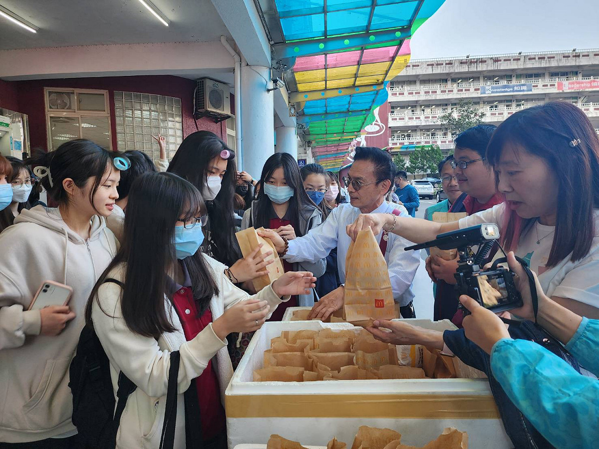 大都會客運和基隆女中今天一起招待搭乘首航的師生們每人一份麥當勞餐點；圖為校長陳明印（中）發送餐點。 圖：大都會客運提供