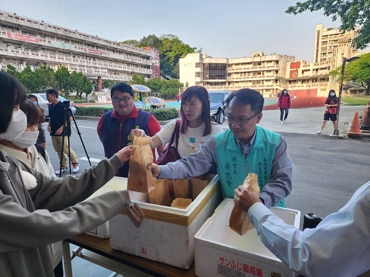 陽明交大敎授王晉元之妻、基隆女中敎師章娟（右二）與基隆市家長協會總會長黃忠賢（右一），一起發送搭乘首航的師生們麥當勞餐點。 圖：大都會客運提供