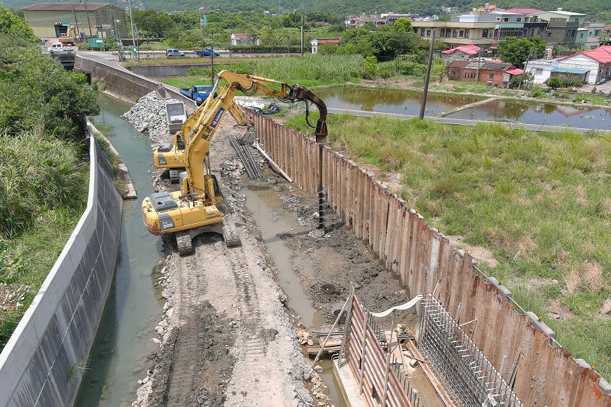 新設疏洪箱涵位於既有防汛道路下方，考量車行承載基礎採鑽掘樁方式施工。 圖：新北市水利局提供