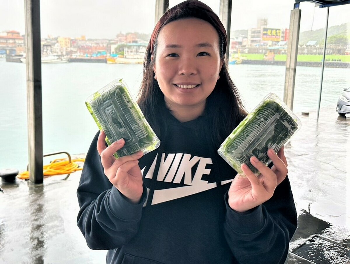新勝發漁業吳凱婷展示盒裝鵝仔菜商品。 圖：新北市漁業處提供