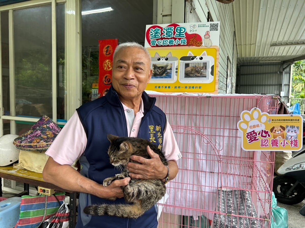 塗潭里長邱秀雄抱認養小站貓咪，呼籲民眾認養。 圖：新北市動保處