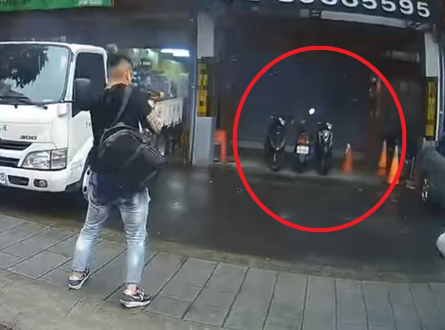 新北17歲少年槍手拿著衝鋒槍朝著當鋪連掃數十槍，當鋪外三台機車慘遭波及。 圖:翻攝畫面