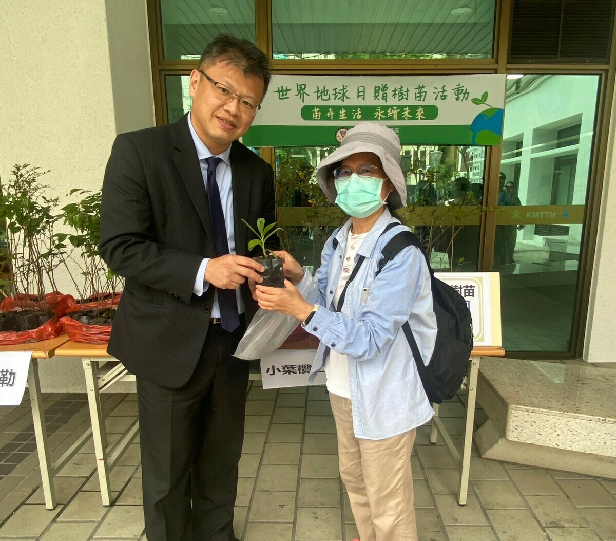 洪仁宇(左)發放樹苗給民眾一起種植。 圖：高雄市立大同醫院/提供