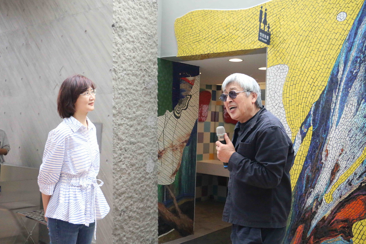 藝術家曲德義 (右)進行藝術街坊洗手間的作品導覽〈形色與色〉。 圖：新北市文化局提供