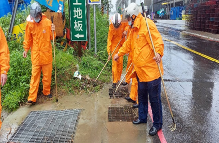 偵水志工於降雨初期進行進水口落葉排除。 圖：新北市水利局提供
