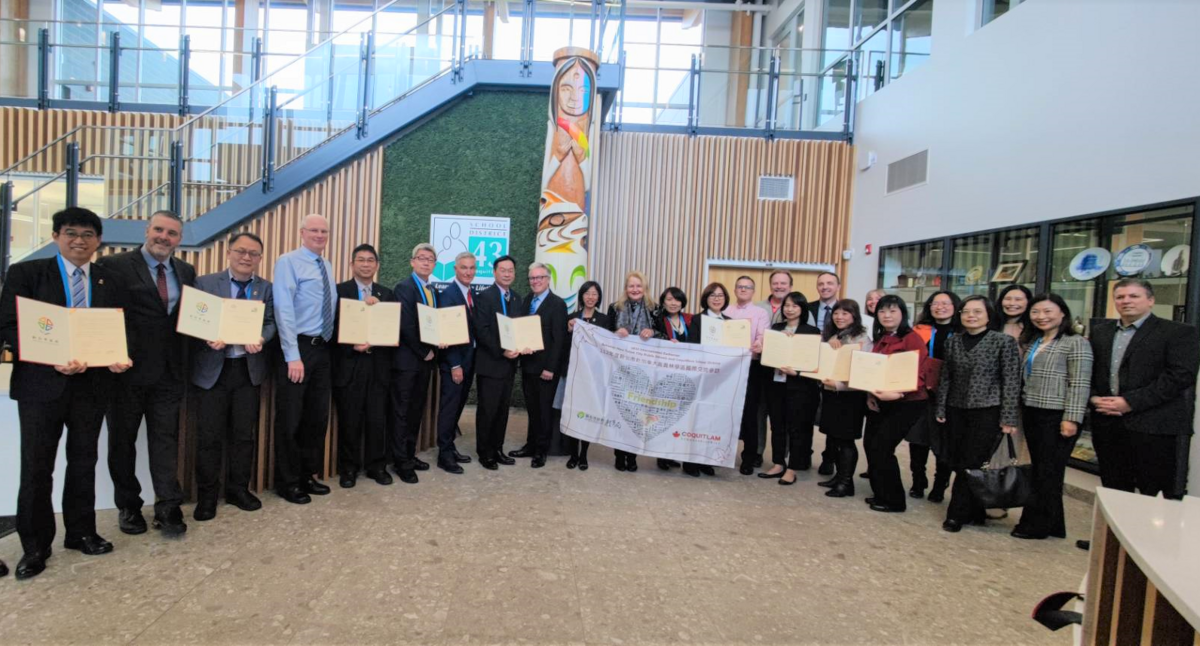 新北市11校與加拿大高貴林學區學校簽署MOU，教育局主任祕書丁雅君(圖中持旗幟左1)、該區教育局長Patricia_Gartland(圖中持旗幟左2)共同見證。 圖：新北市教育局提供