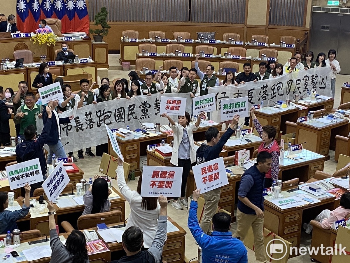 綠議員舉布條抗議國民黨幫凶侯友宜落跑，國民黨議員則舉牌反控要民進黨不要鬧。 圖：林昀真/攝