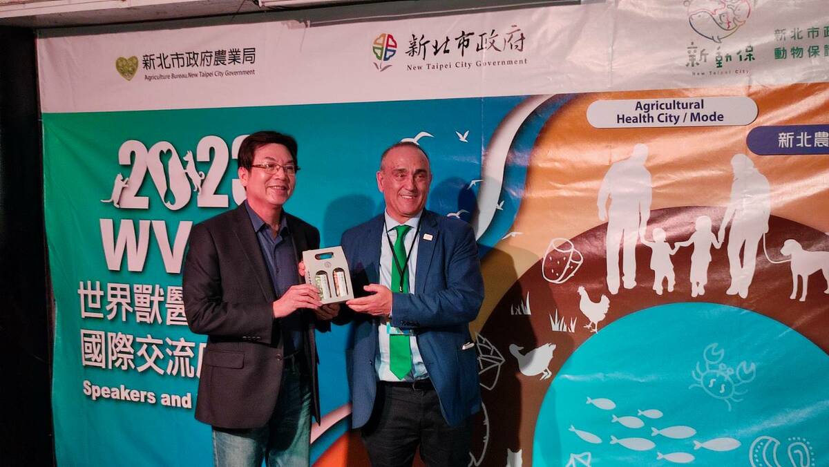 新北市副市長劉和然致贈茶慶酒給世界獸醫師會長拉菲爾。 圖：新北市動保處提供